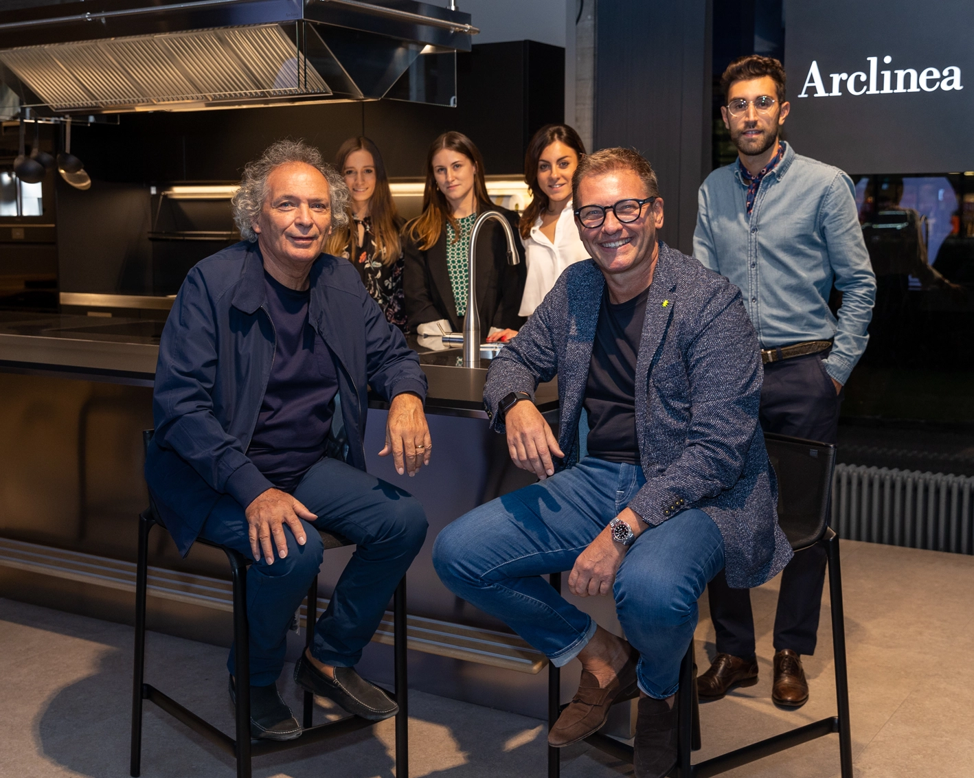 Photography by the Fontana team. The two founders are sitting on two stools in the foreground, while behind them are four staff members